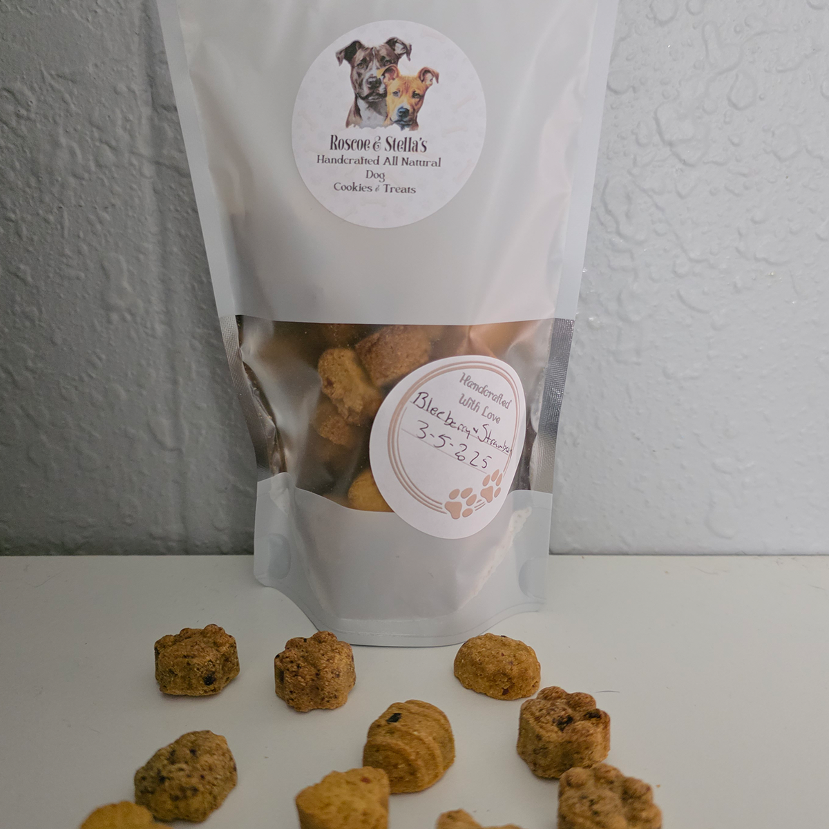 Bag of Roscoe and Stellas Handmade All Natural Dog Treats with a label on a white surface
