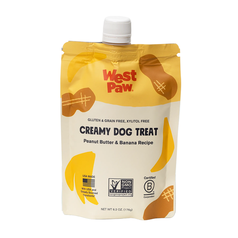 Front view of a 6.2 oz squeezable pouch of West Paw Creamy Dog Treat in Peanut Butter and Banana Recipe, featuring gluten-free, grain-free, and xylitol-free labeling.