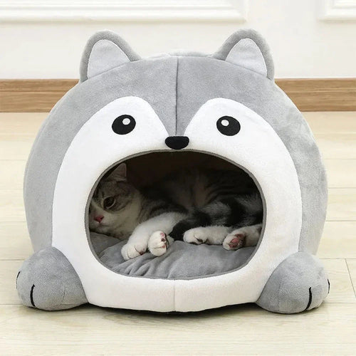 Cat lying inside a gray pet bed shaped like a husky face on a wooden floor.