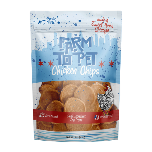 A stand-up pouch of Farm to Pet Chicken Chips dog treats on a plain white background. The packaging is primarily light blue with red and white text, a clear window showing the round tan chips inside, and a chicken illustration near the bottom right.
