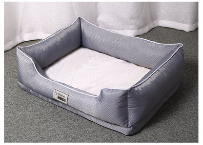 Grey rectangular dog bed with white piping and supportive bolster walls on a textured floor.