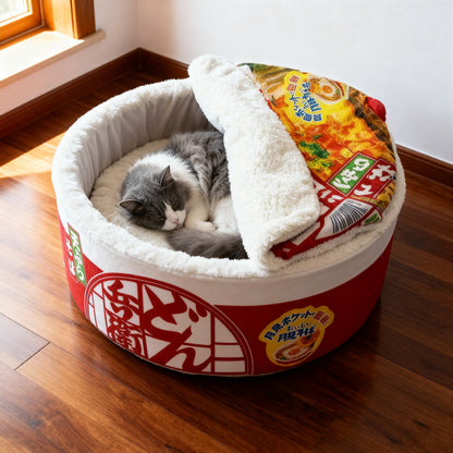 Grey and white cat sleeping inside a plush Japanese ramen cup noodle pet bed on a walnut floor in a mid-century modern living room from Paws & Pockets