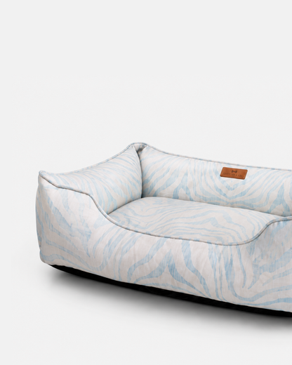 Chester & Lee luxury velvet sleeper dog bed featuring a blue and white animal print pattern and supportive bolsters.