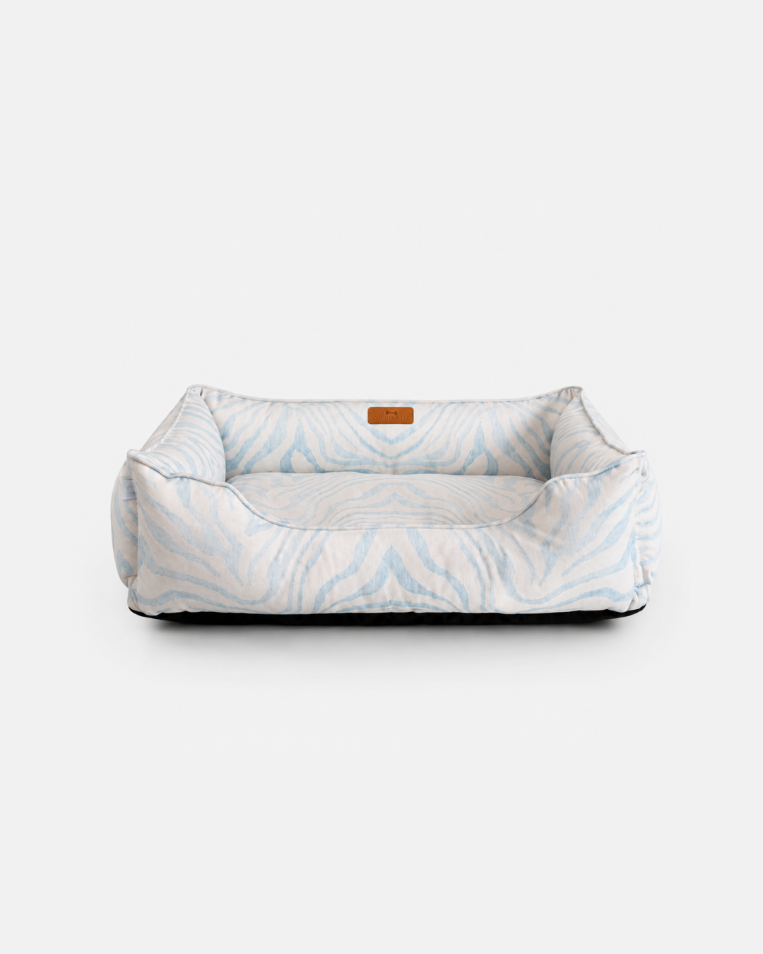 Chester & Lee luxury sleeper dog bed in a blue patterned fabric with supportive cushioned bolsters against a neutral background