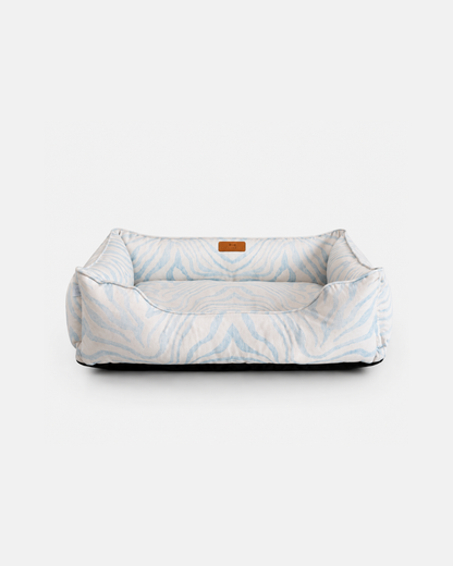 Chester & Lee luxury sleeper dog bed in a blue patterned fabric with supportive cushioned bolsters against a neutral background