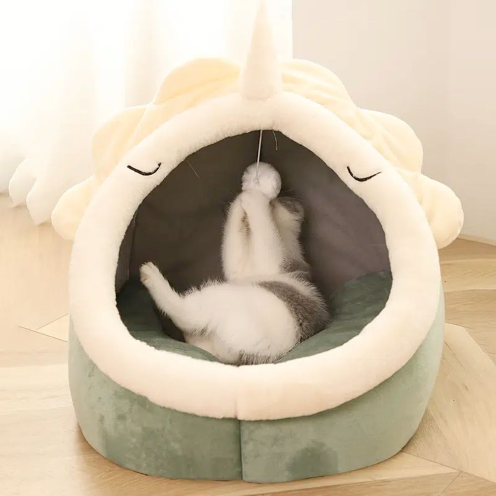 Dinosaur cat cave bed interior view showing soft coral fleece cushion and semi-enclosed hooded design for anxious pets