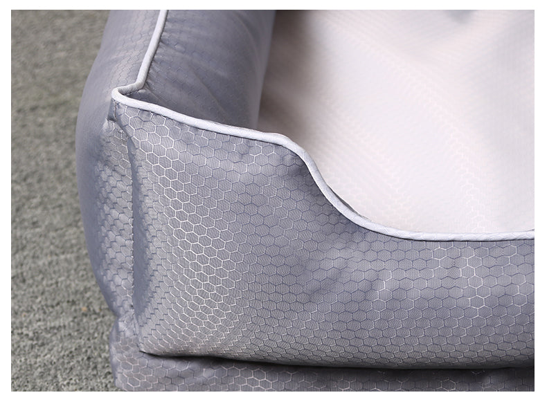 ⁠Close-up detail of the grey hexagonal pattern fabric and reinforced white-trimmed bolster on a Paws & Pockets removable pet bed