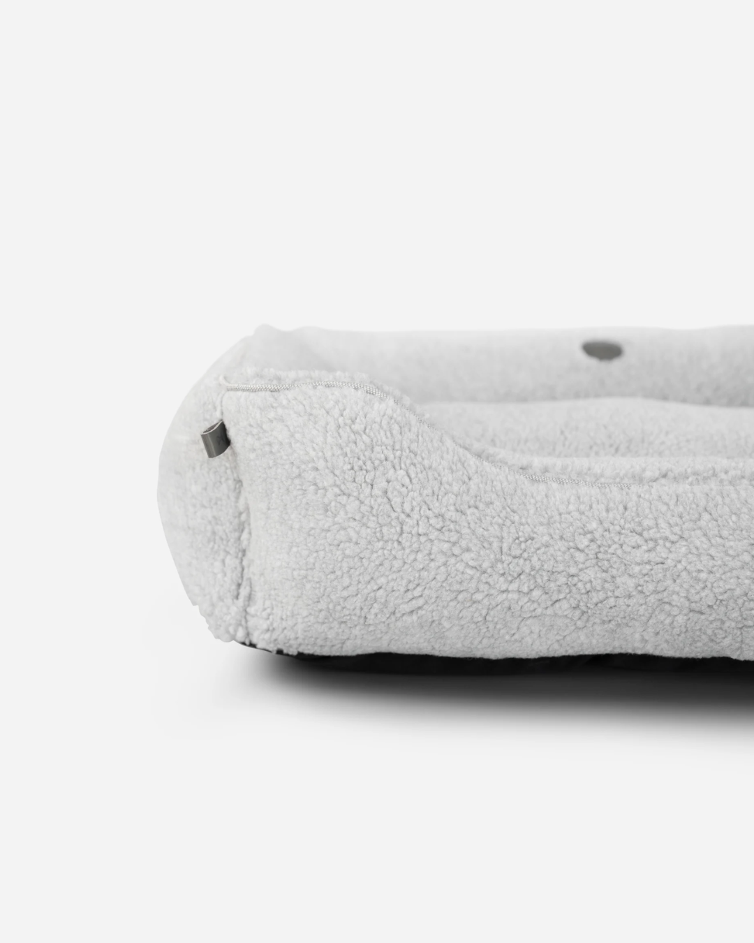 Chester and Lee luxury furry sleeper dog bed in gray with a small black poodle sitting inside, styled in a modern living room.