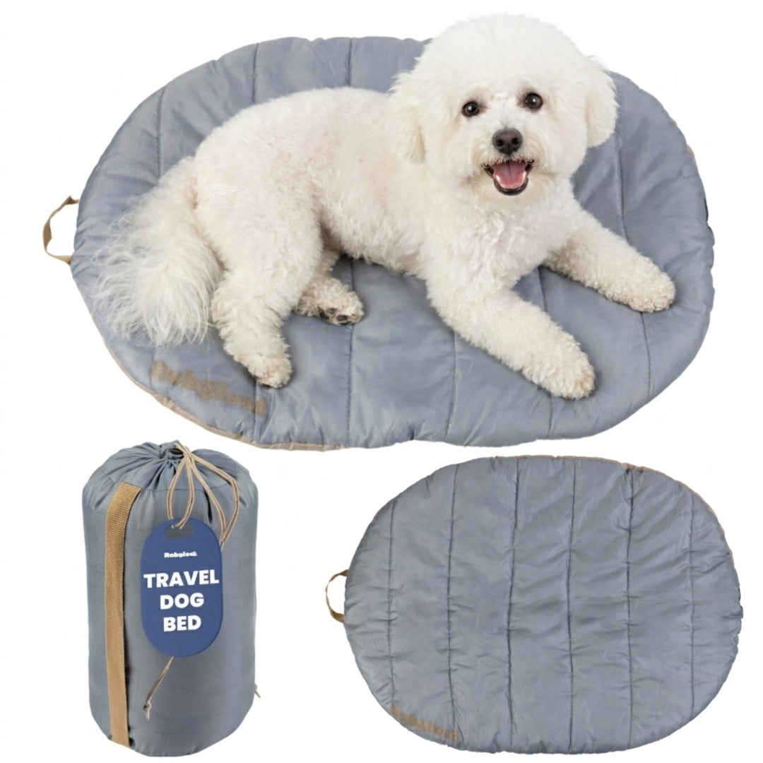 A fluffy white poodle mix lounging on a small grey Rubyloo roll-up travel dog bed paired with a compact cinch carry bag.