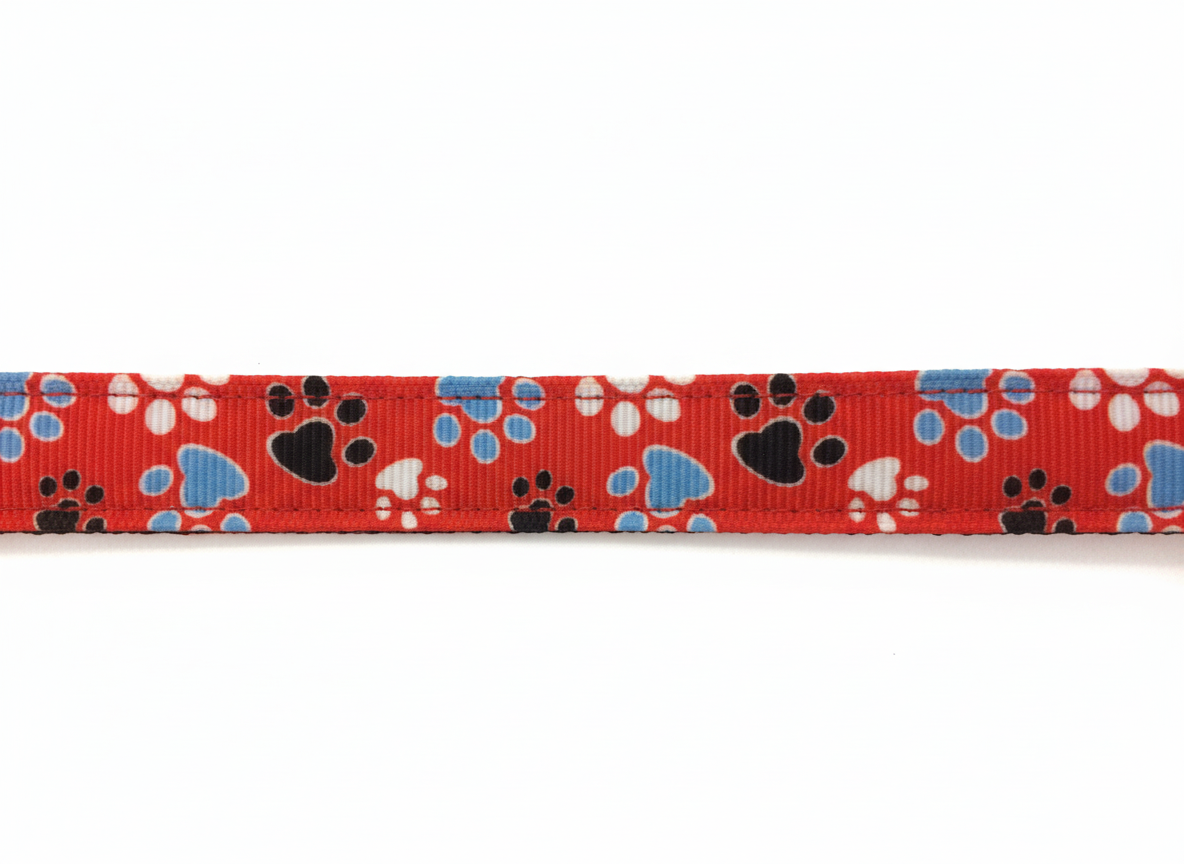 Red adjustable dog collar with blue and white paw prints for small dogs.