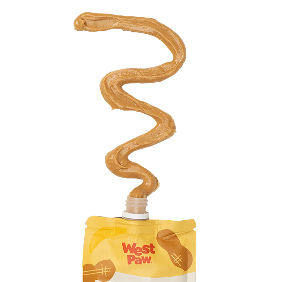 Creamy peanut butter and banana dog treat paste squeezed in a smooth squiggly line from a West Paw pouch nozzle